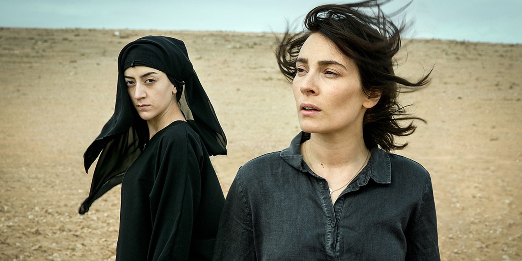 Gizem Erdogan and Aliette Opheim as Pervin and Fatima, standing in the desert in Caliphate