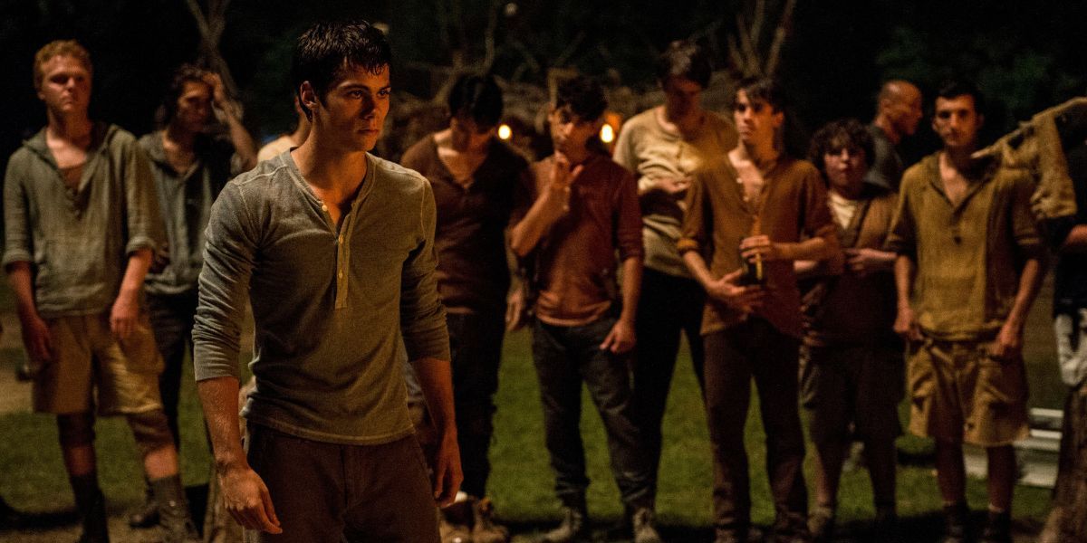 Thomas, played by Dylan O'Brien, standing in front of a crowd of other boys in The Maze Runner.
