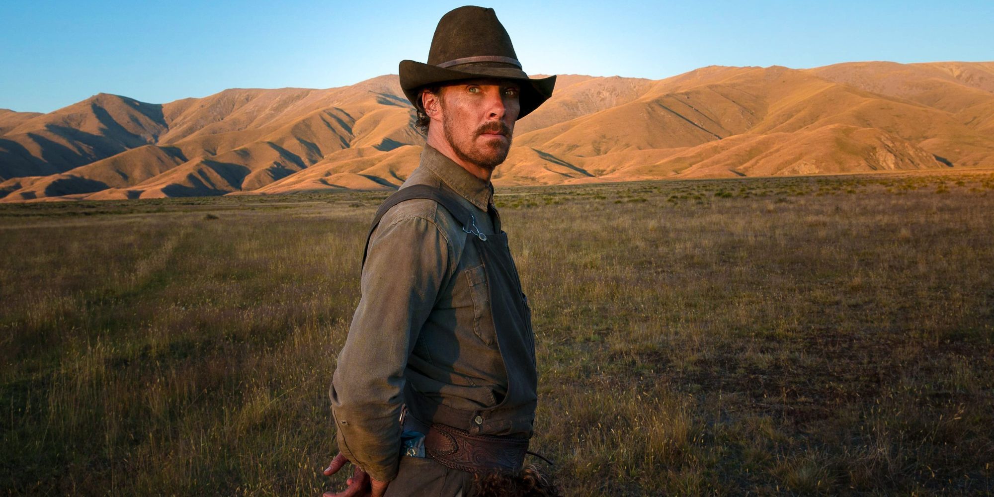 Phil Burbank standing in an open field in The Power of the Dog