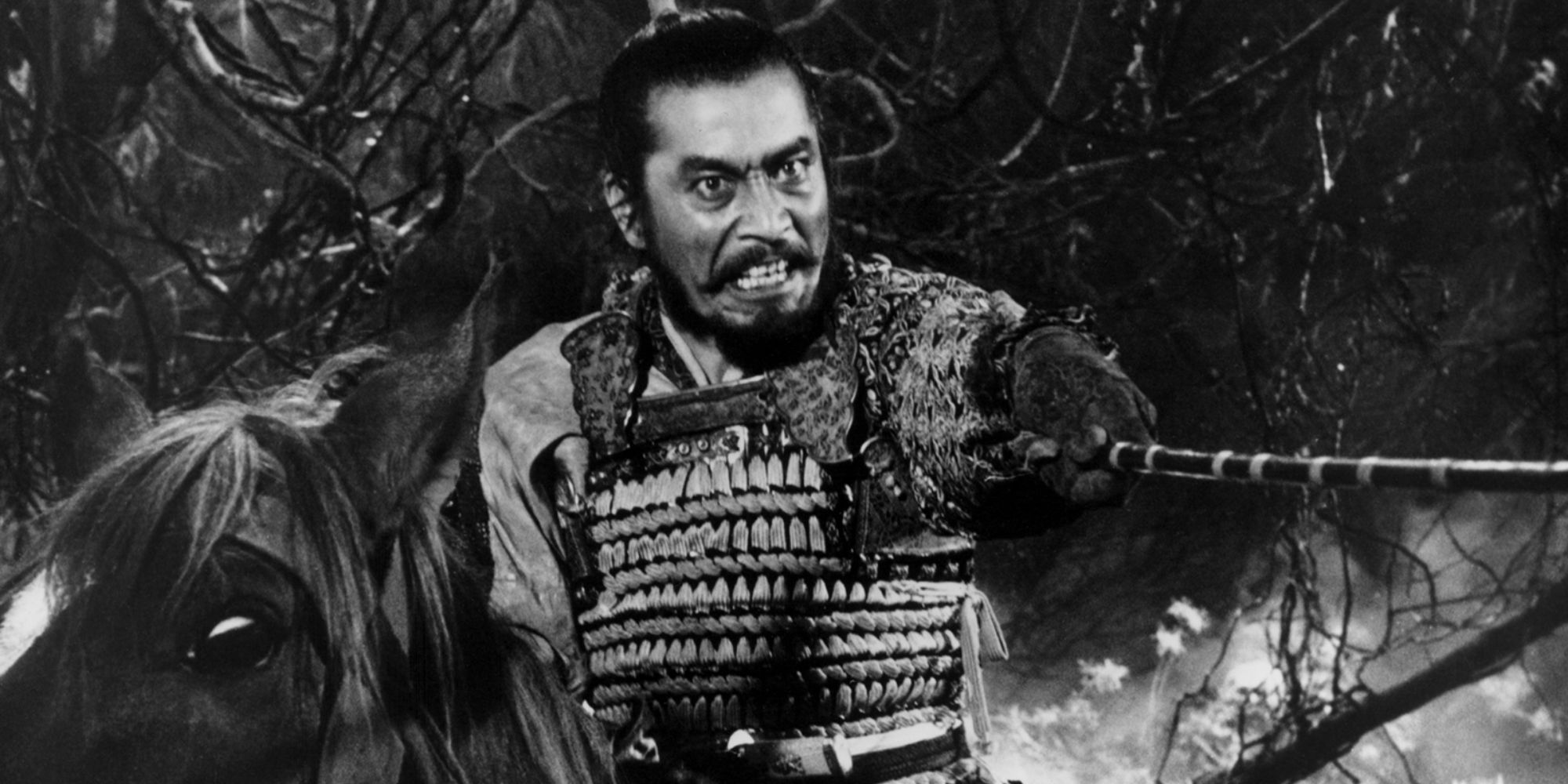 Toshiro Mifune, astride a horse, points his katana threateningly in Throne of Blood