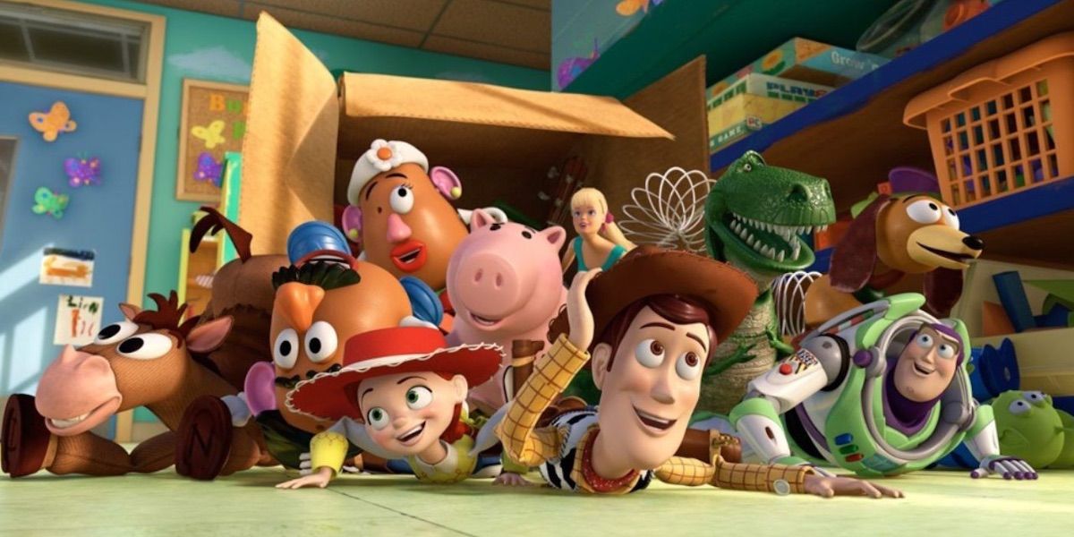 Woody and his toy friends falling out of a box and smiling in Toy-Story-3