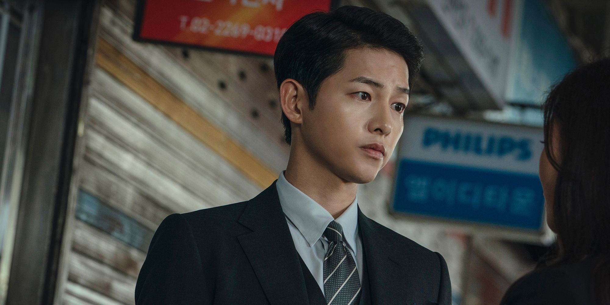 Vincenzo Cassano from Vincenzo played by Song Joong-ki looking worriedly at a woman.