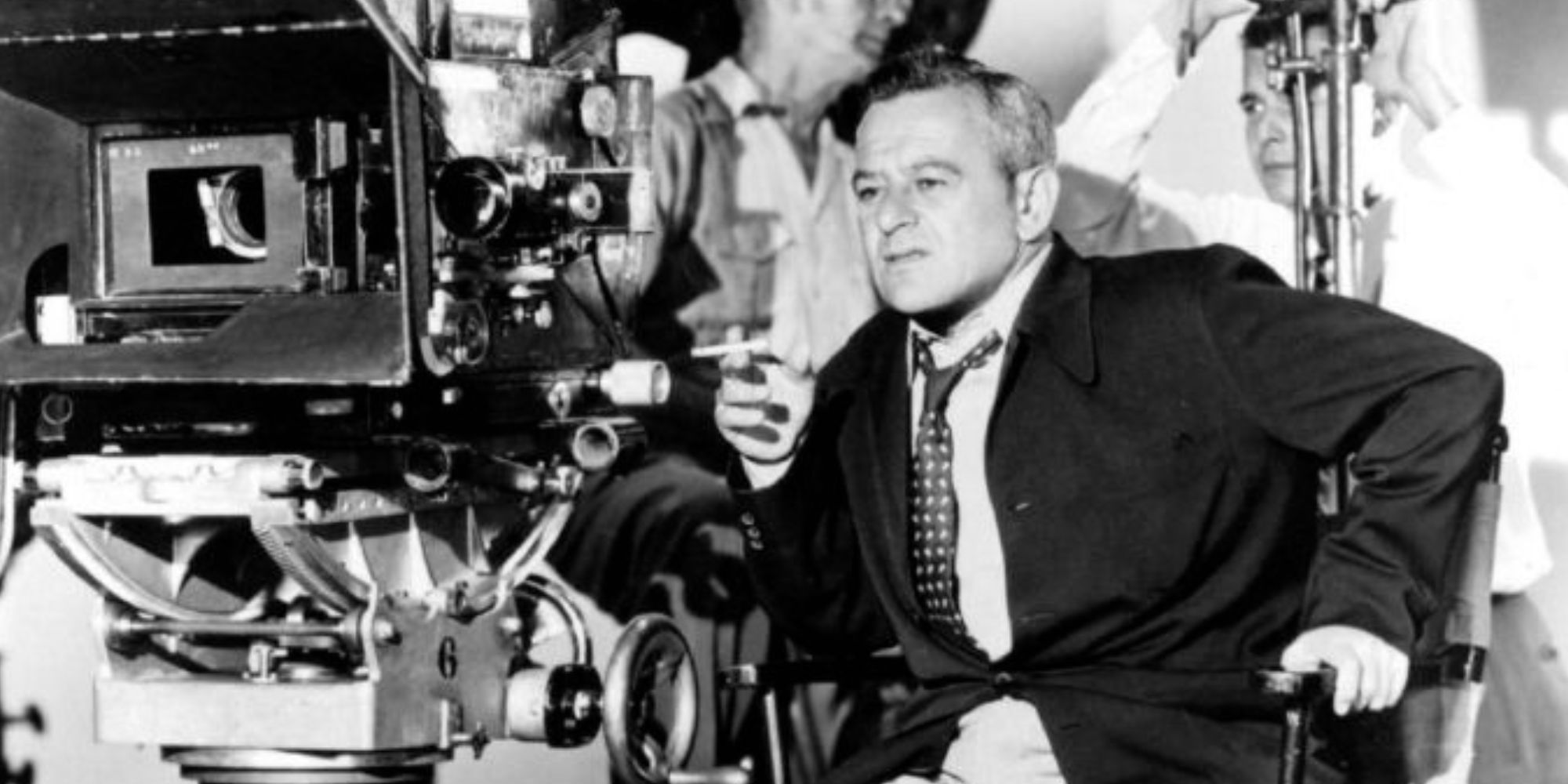 William Wyler sitting next to a camera on set looking forward via Directed by William Wyler documentary (1986)