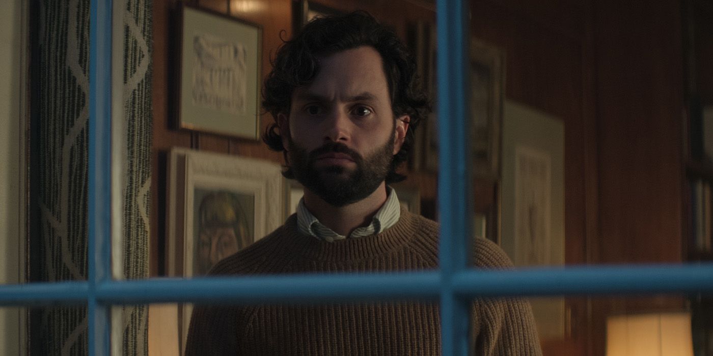 Penn Badgley dans le rôle de Joe Goldberg regardant par la fenêtre de son appartement dans la saison 4 de 'You'.