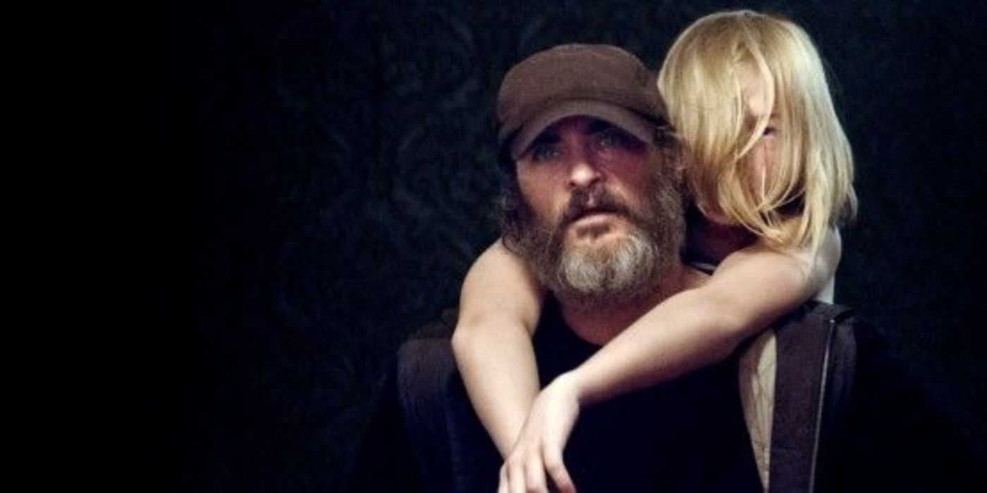 Joaquin Phoenix as Joe carrying Nina, played by Ekaterina Samsonov, on his back in 'You Were Never Really Here.'