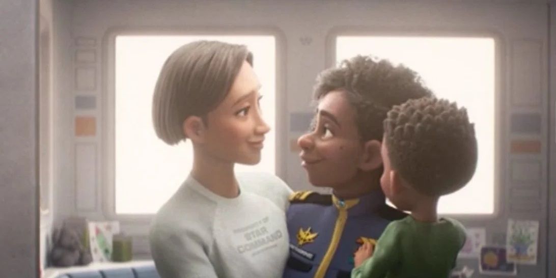 Alisha and Kiko Hawthorne gazing into each other's eyes while holding a small boy in Lightyear