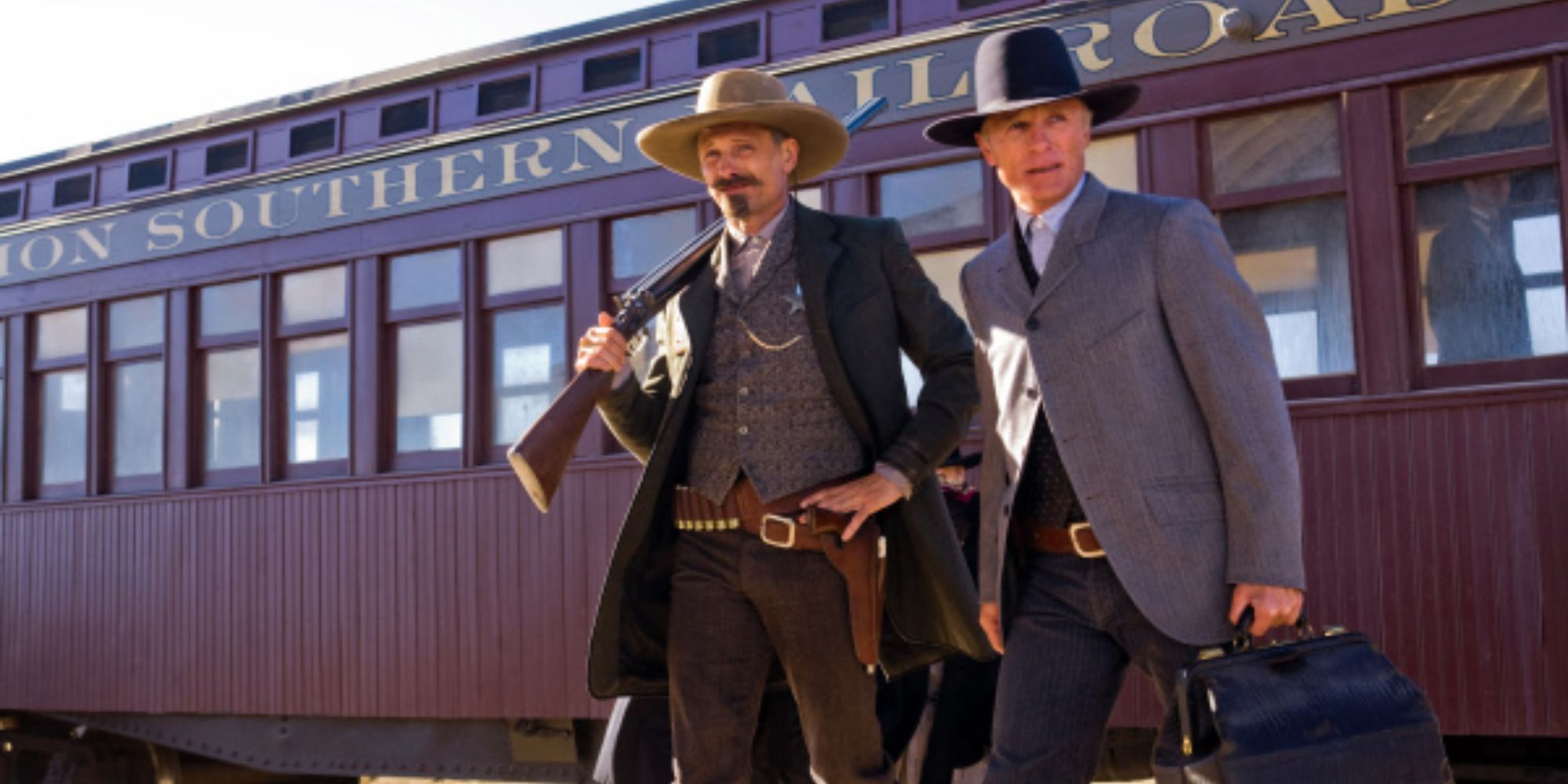 Two men with a train behind them in Appaloosa