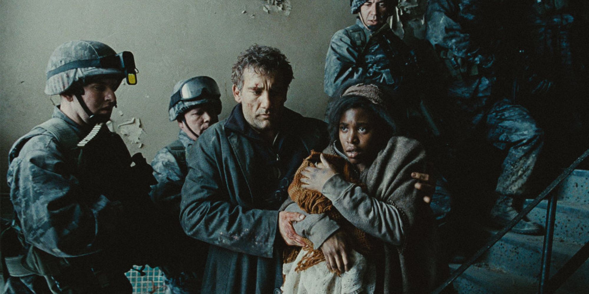 clive owen and clare hope ashitey as theo faron and kee huddling amongst soldiers