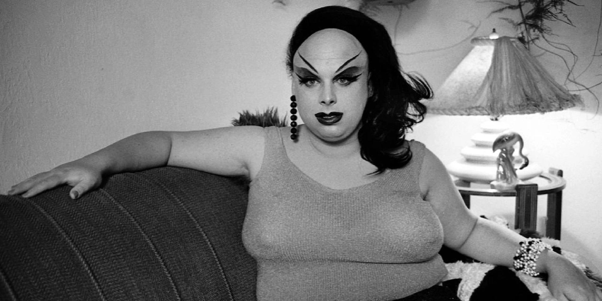 Drag queen Divine seating on the sofa in 'I Am Divine'