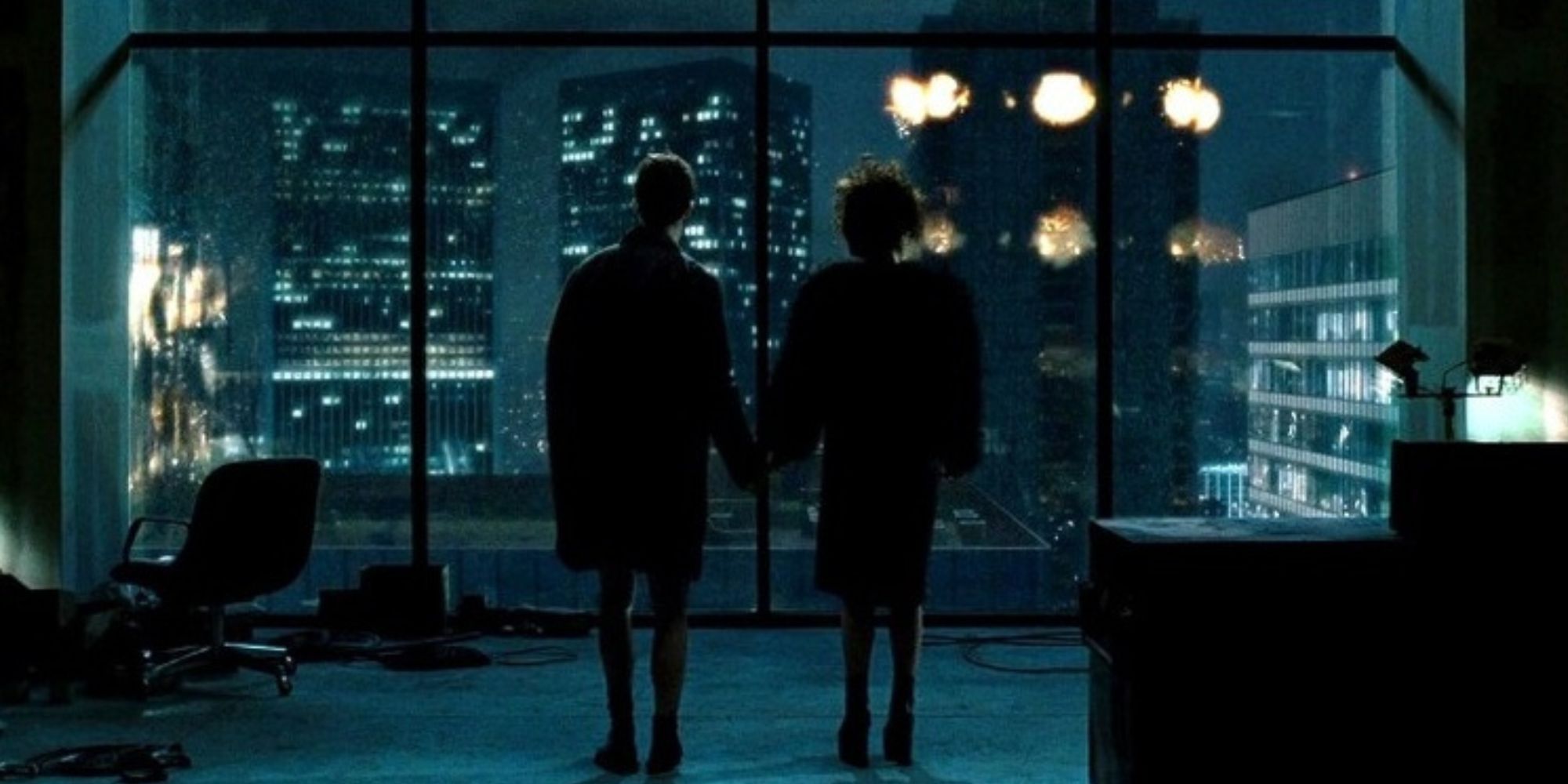 The Narrator and Marla holding hands, watching buildings blow up in 'Fight Club'