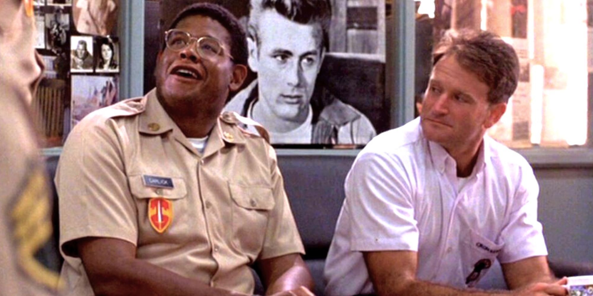 Forest Whitaker looking up while sitting next to Robin Williams in Good Morning, Vietnam