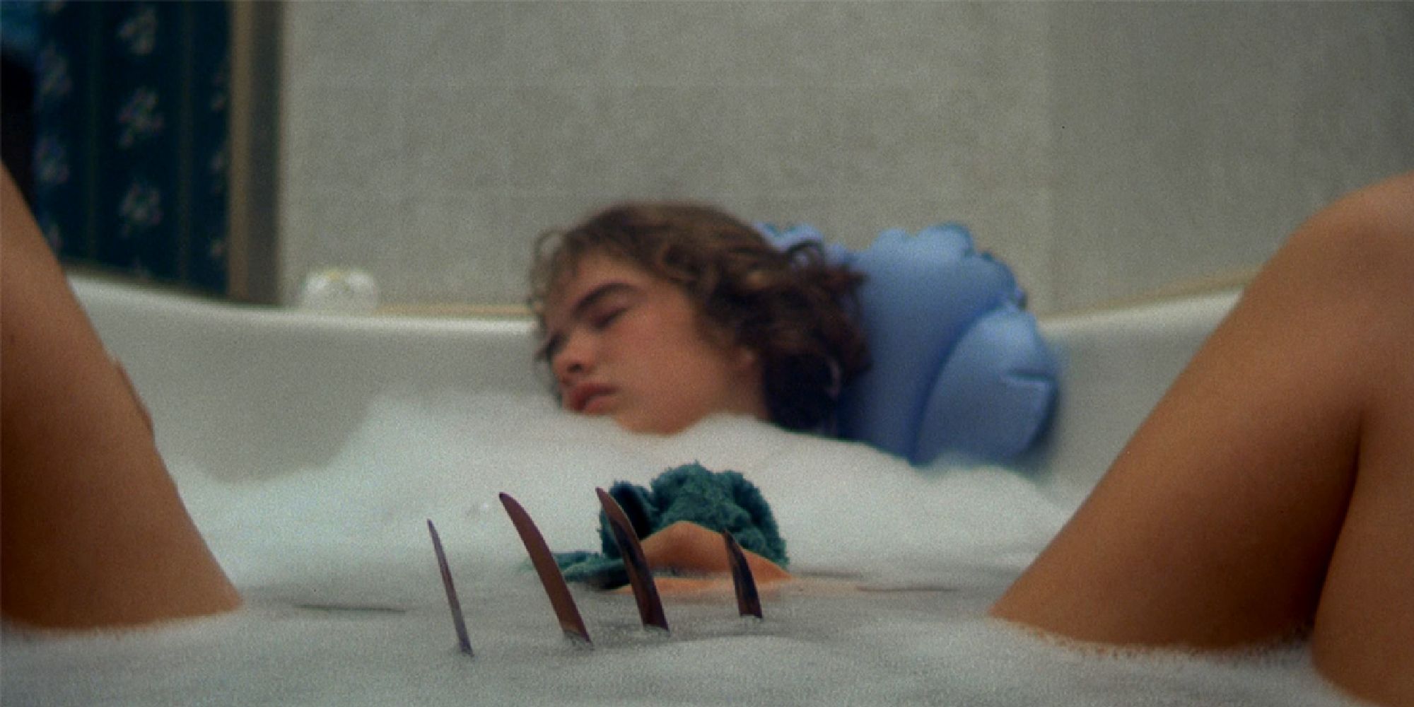 Freddy Krueger's claws about to attack Heather Langenkamp's character in the bath in 'Nightmare on Elm Street'