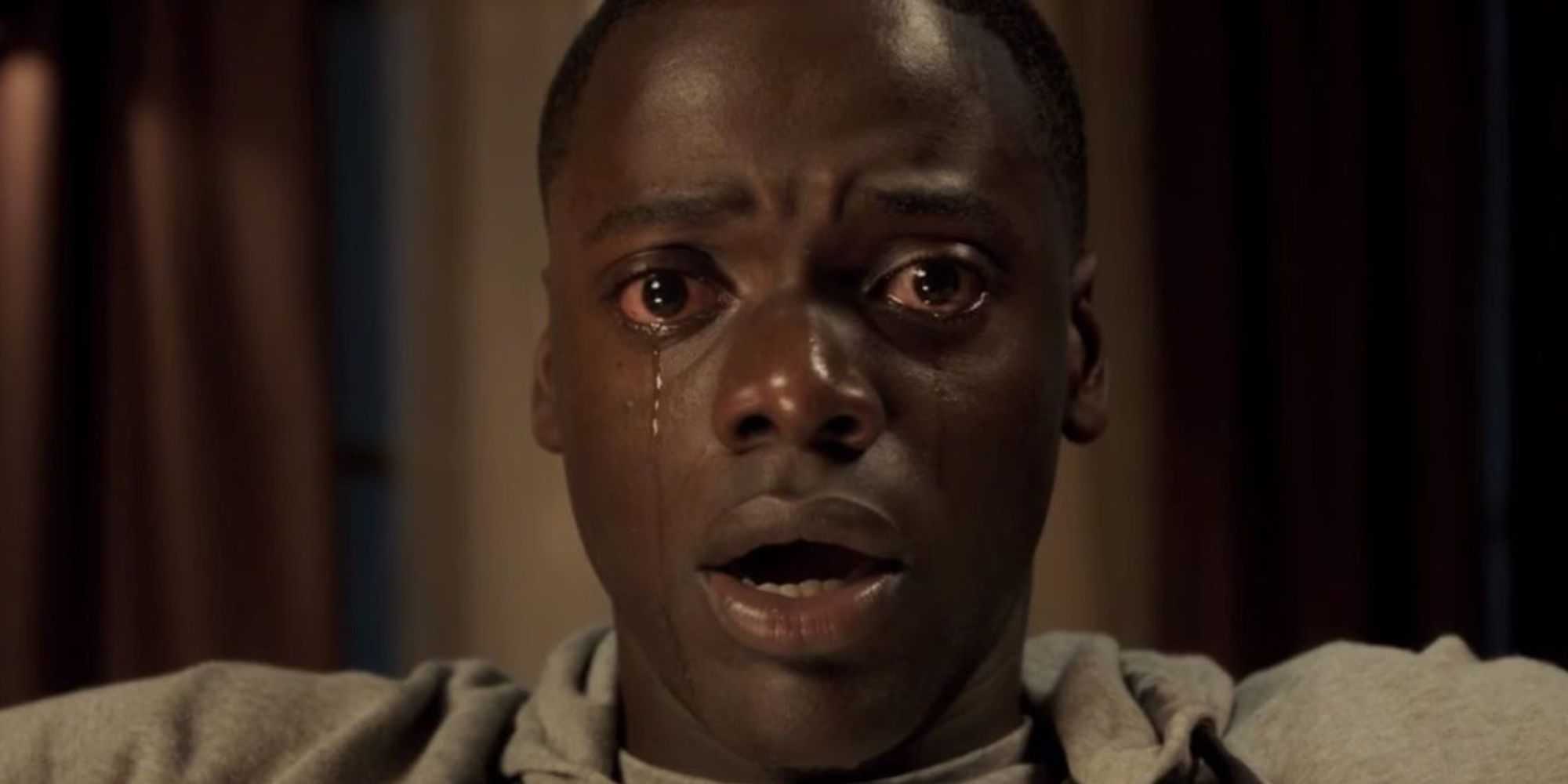 Daniel Kaluuya as Chris Washington crying and looking shocked in Get Out.