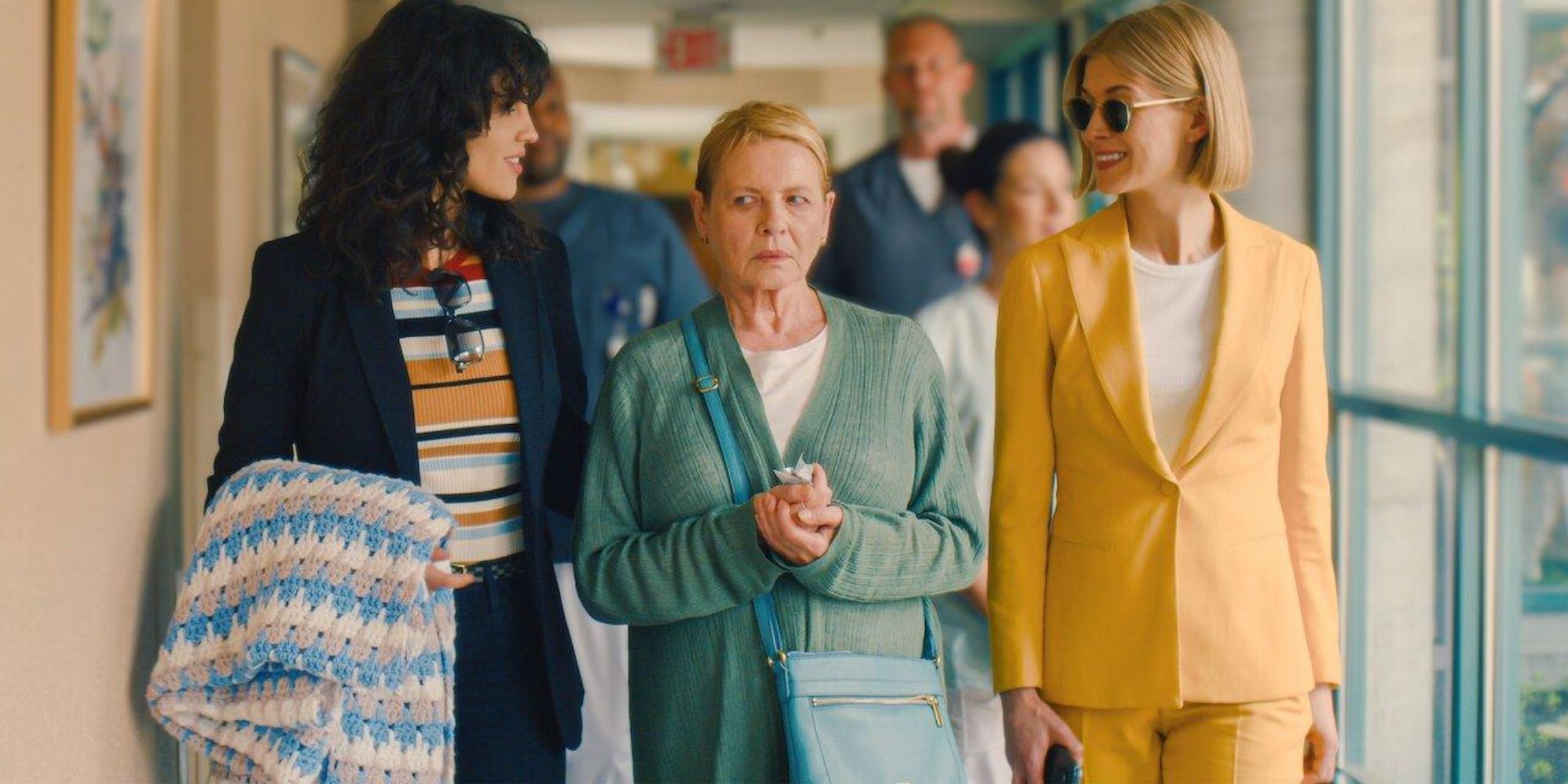 Jennifer (Dianne Wesit) being escorted through a care facility by Marla (Rosamund Pike) and Fran (Eiza Gonzalez)