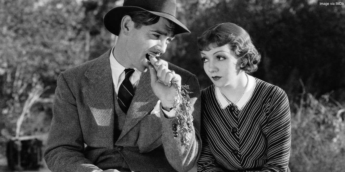 Clark Gable comendo uma cenoura sentado ao lado de Claudette Colbert em It Happened One Night