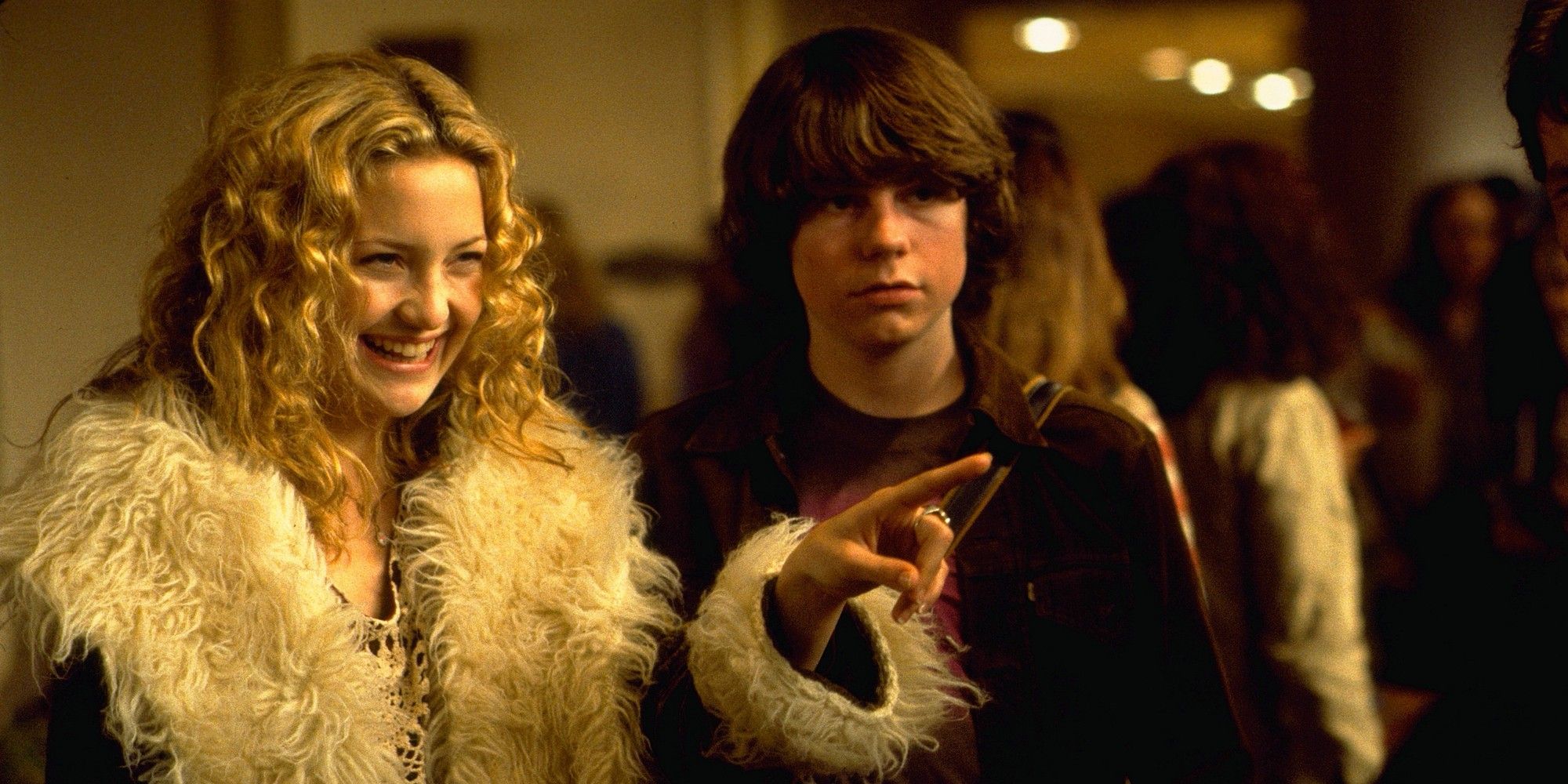 Kate Hudson pointing at something and smiling beside Patrick Fugit in Almost Famous