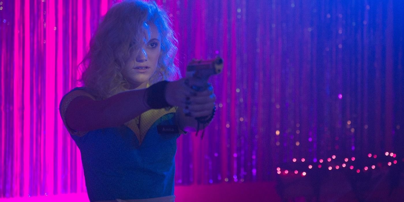 Maika Monroe pointing a gun in The Guest