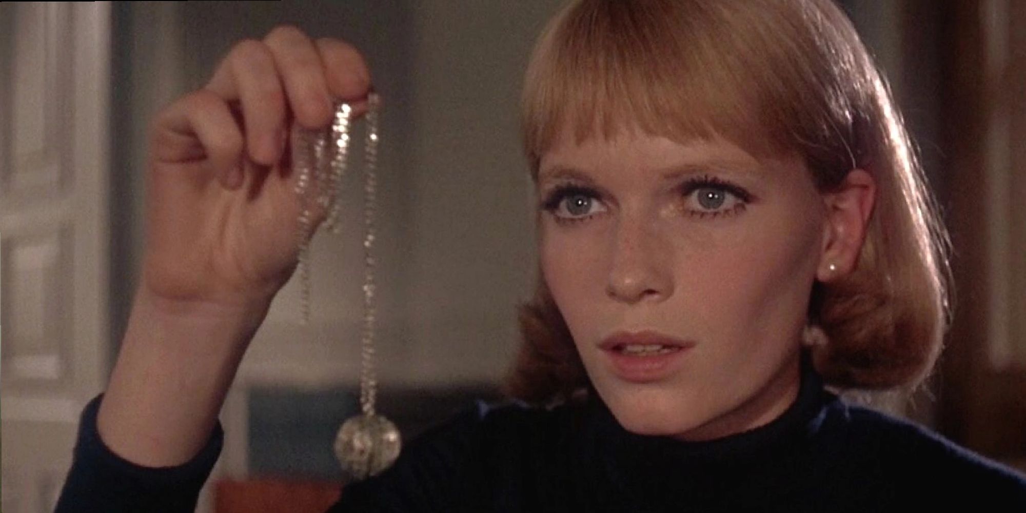 Mia Farrow holding a necklace in 'Rosemary's Baby'