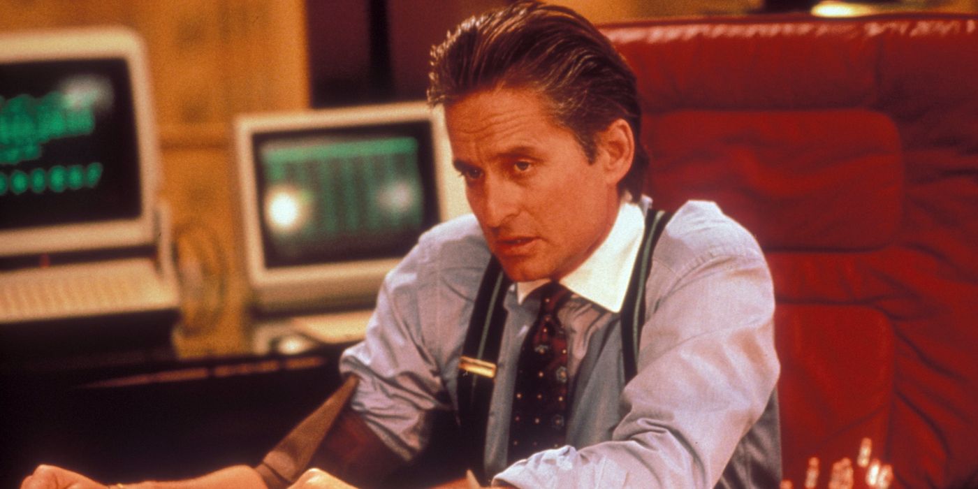 Michael Douglas sebagai Gordon Gekko duduk di mejanya di Wall Street