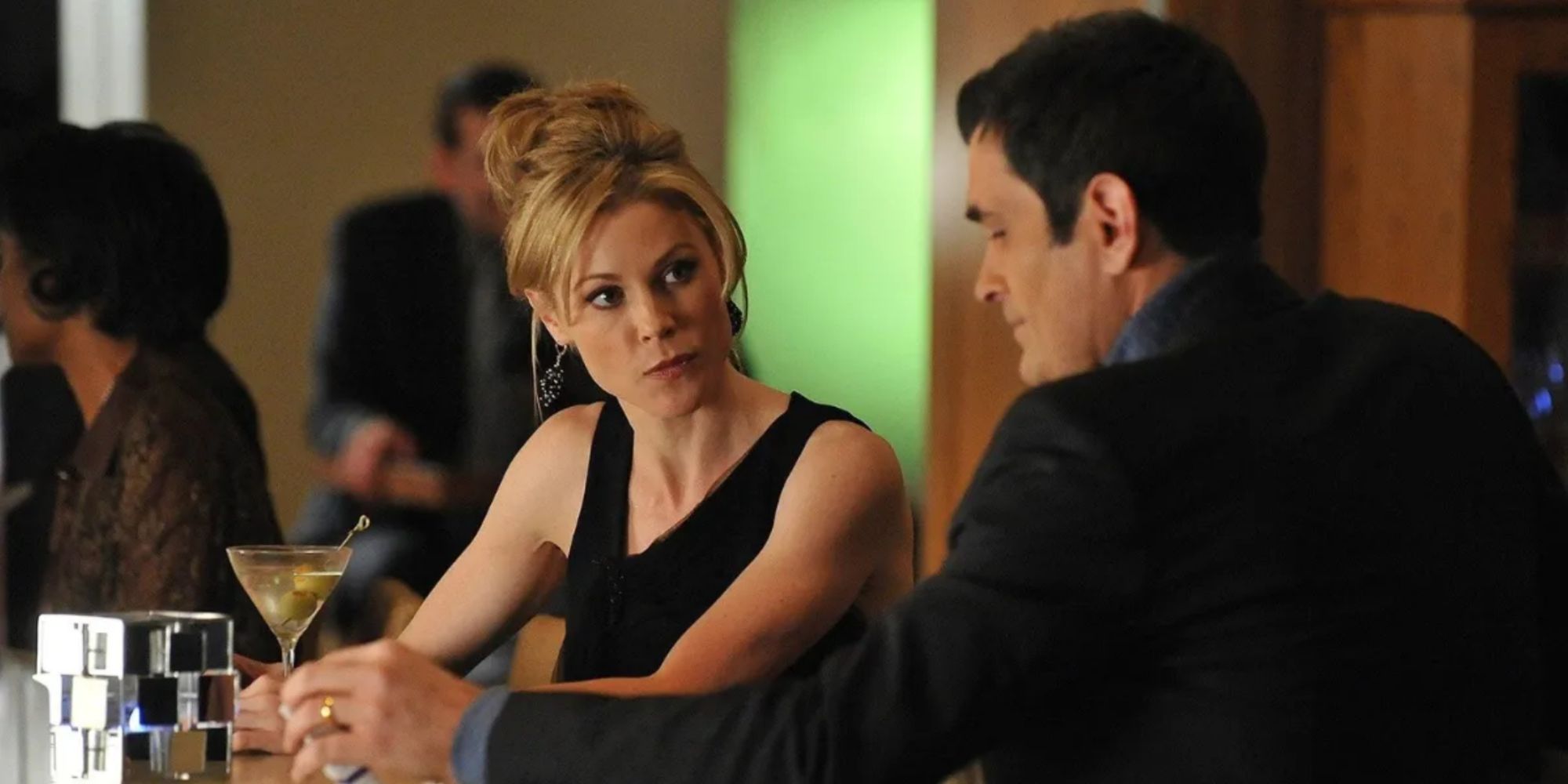 Julie Bowen and Ty Burrell as Claire and Phil Dunphy sitting at a bar in Modern Family