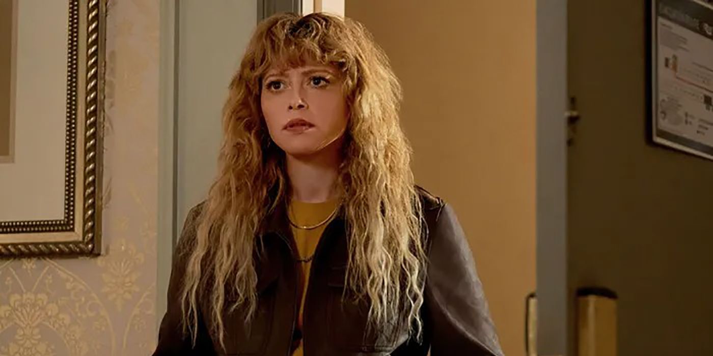 Natasha Lyonne standing in a room looking worried in a scene from Poker Face.