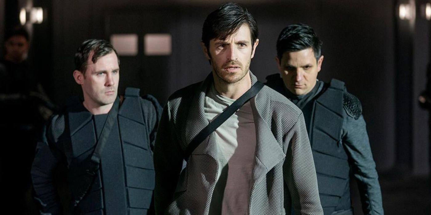 Three men in a dimly lit location walking towards the camera in a scene from Nightflyers.