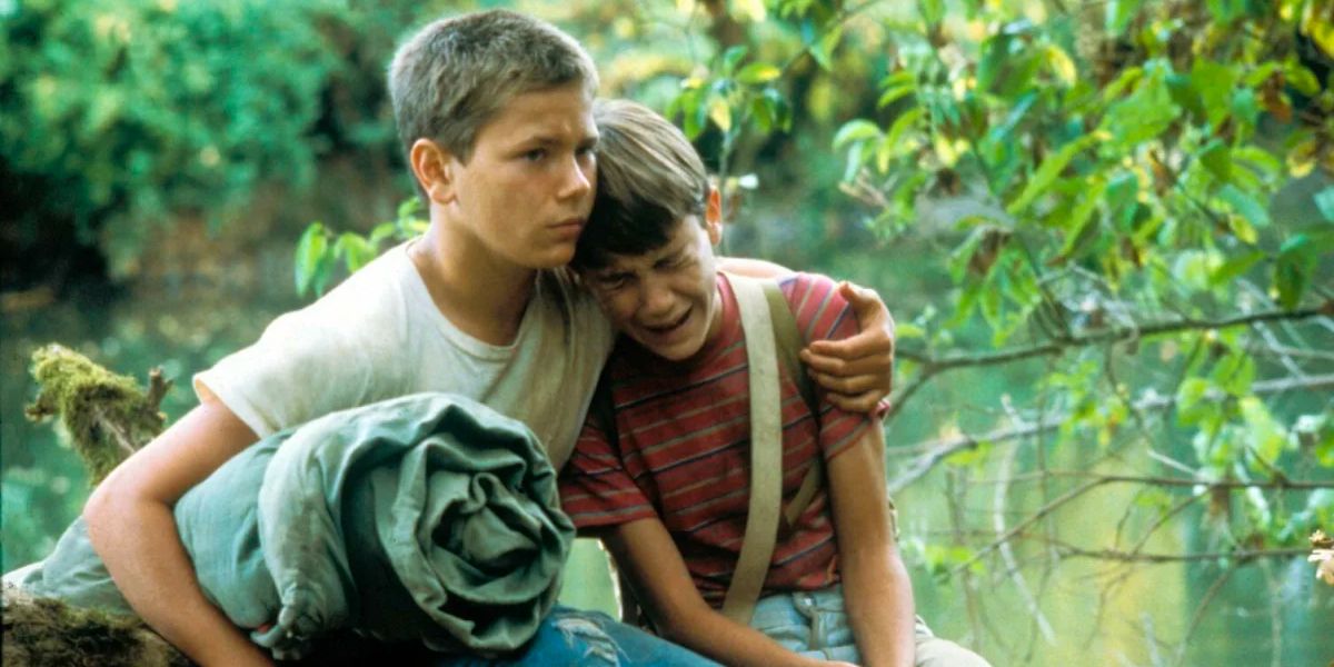 A young boy consoles his upset friend in the woods.
