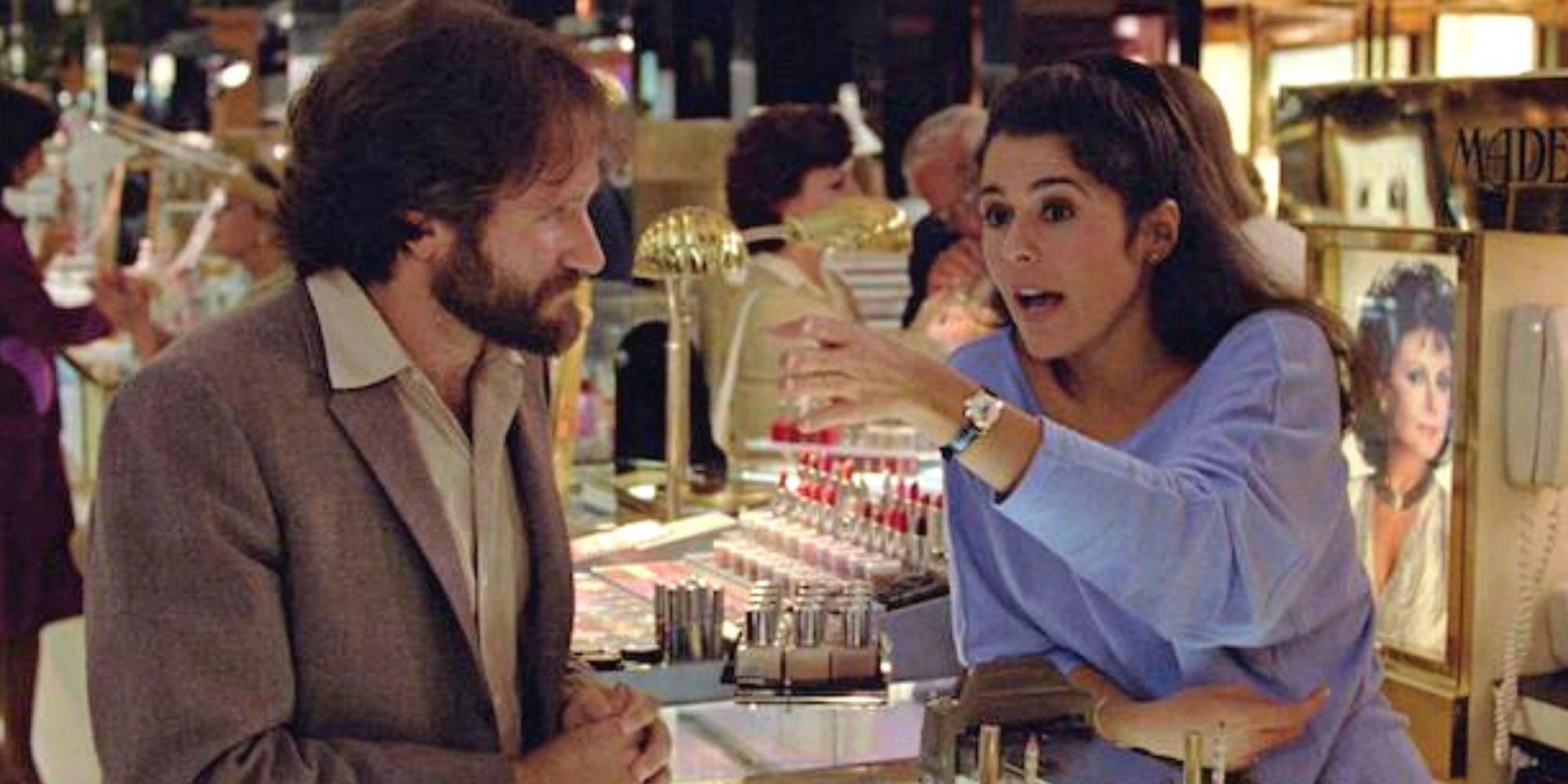 Robin Williams looking at Marie Conchita Alonso behind a sales counter in Moscow of the Hudson