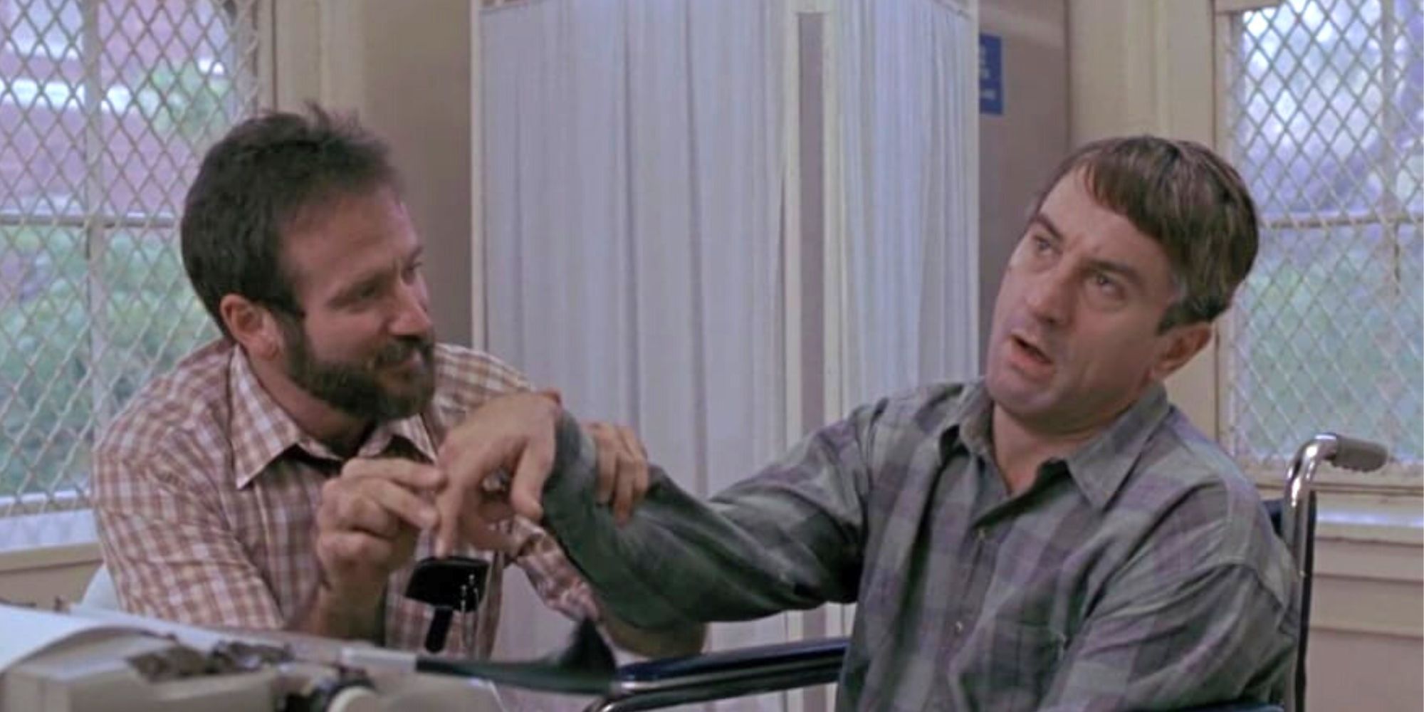 Robin Williams and Robert De Niro as Sean and Leonard working on Leonard's arm therapy in the film Awakenings