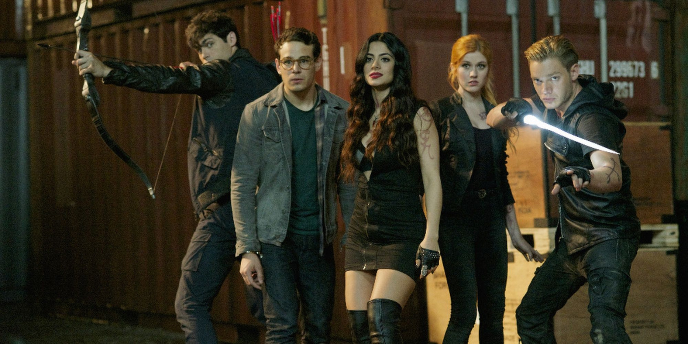 The cast of Shadowhunters (left to right: Matthew Daddario, Alberto Rosende, Emeraude Toubia, Katherine McNamara, Dominic Sherwood) in battle position in front of shipping containers