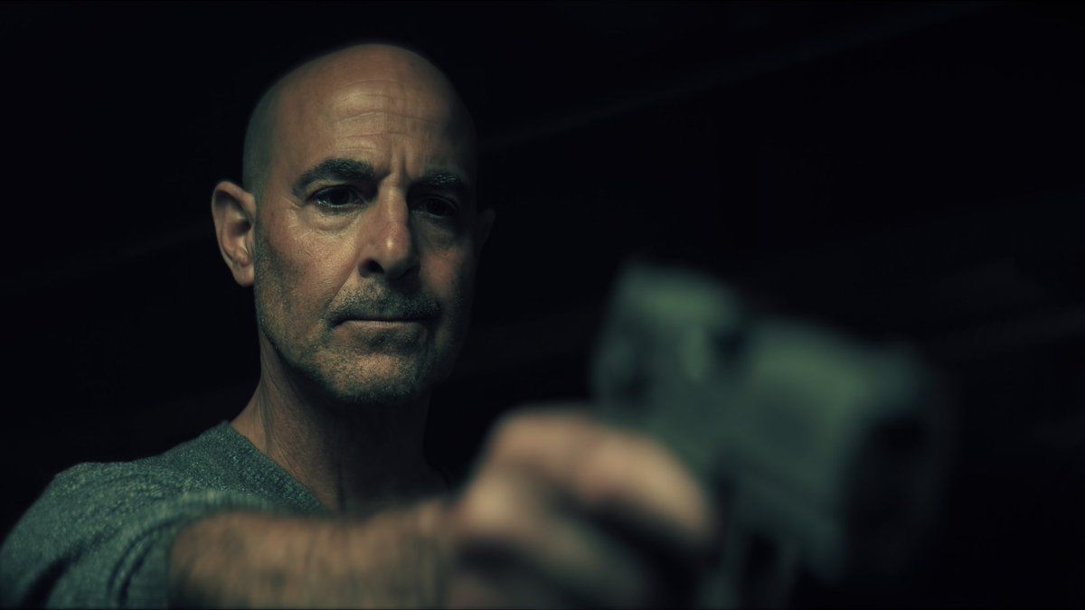 Stanley Tucci holding a gun in Citadel