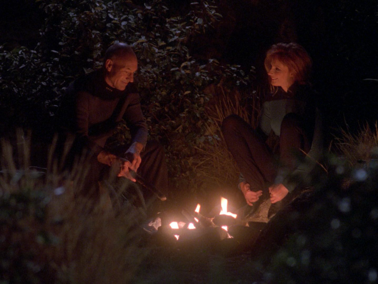 Patrick Stewart dans le rôle de Jean Luc Picard et Gates McFadden dans le rôle de Beverly Crusher assis près d'un feu de camp dans Star Trek : The Next Generation Saison 7 Episode 8 