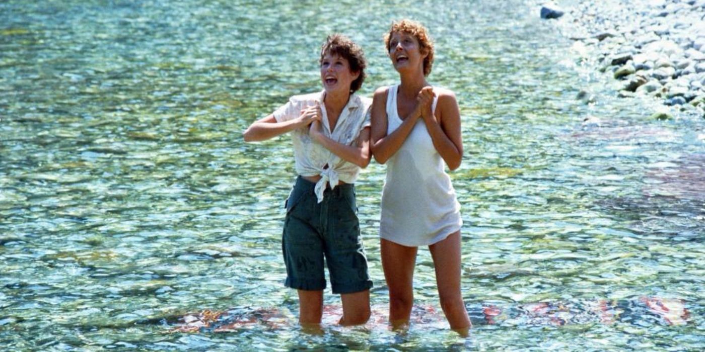 Susan Sarandon as Aretha and Molly Ringwald as Miranda happily singing as they stand in the water in Tempest