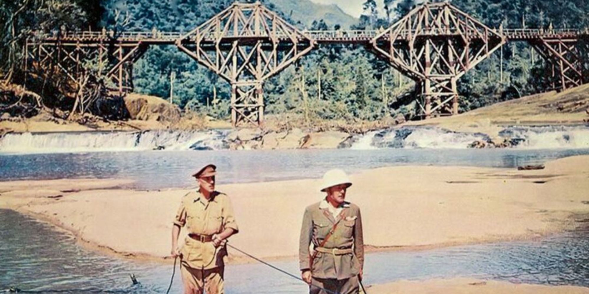 Two soldiers standing in front of a bridge in the daylight in The Bridge on the River Kwai