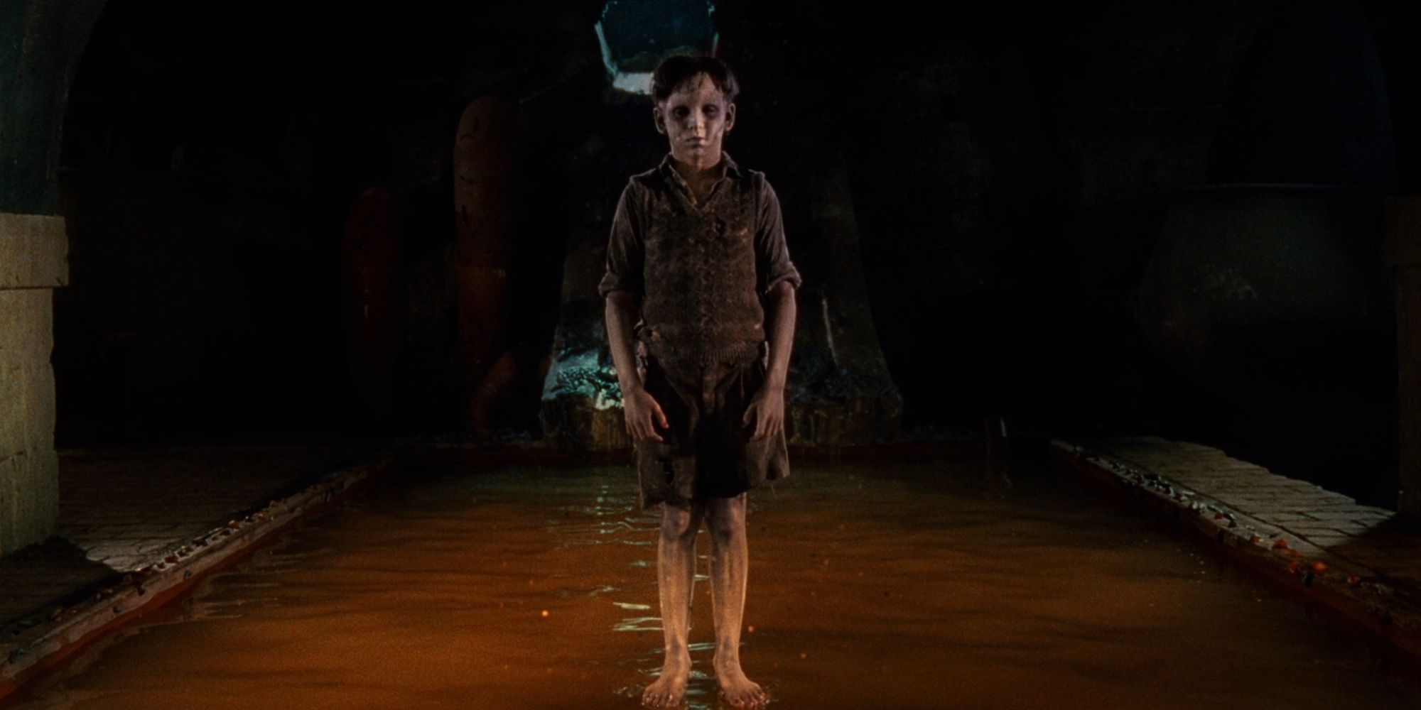 Un garçon effrayant debout au milieu d'un égout dans 'The Devil's Backbone'