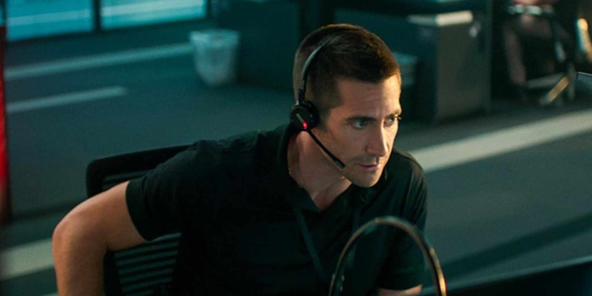 Jake Gyllenhaal, que interpreta a Joe Baylor, se pone unos auriculares y mira fijamente a 