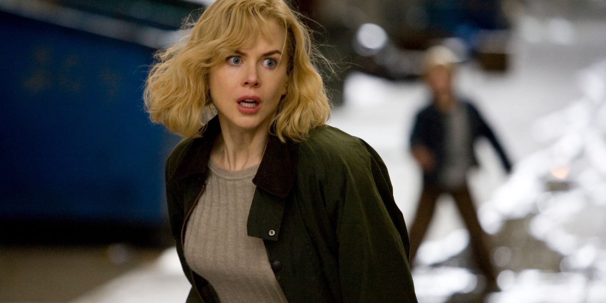 Nicole Kidman debout dans une ruelle avec quelqu'un de plus petit derrière elle dans 'The Invasion'.