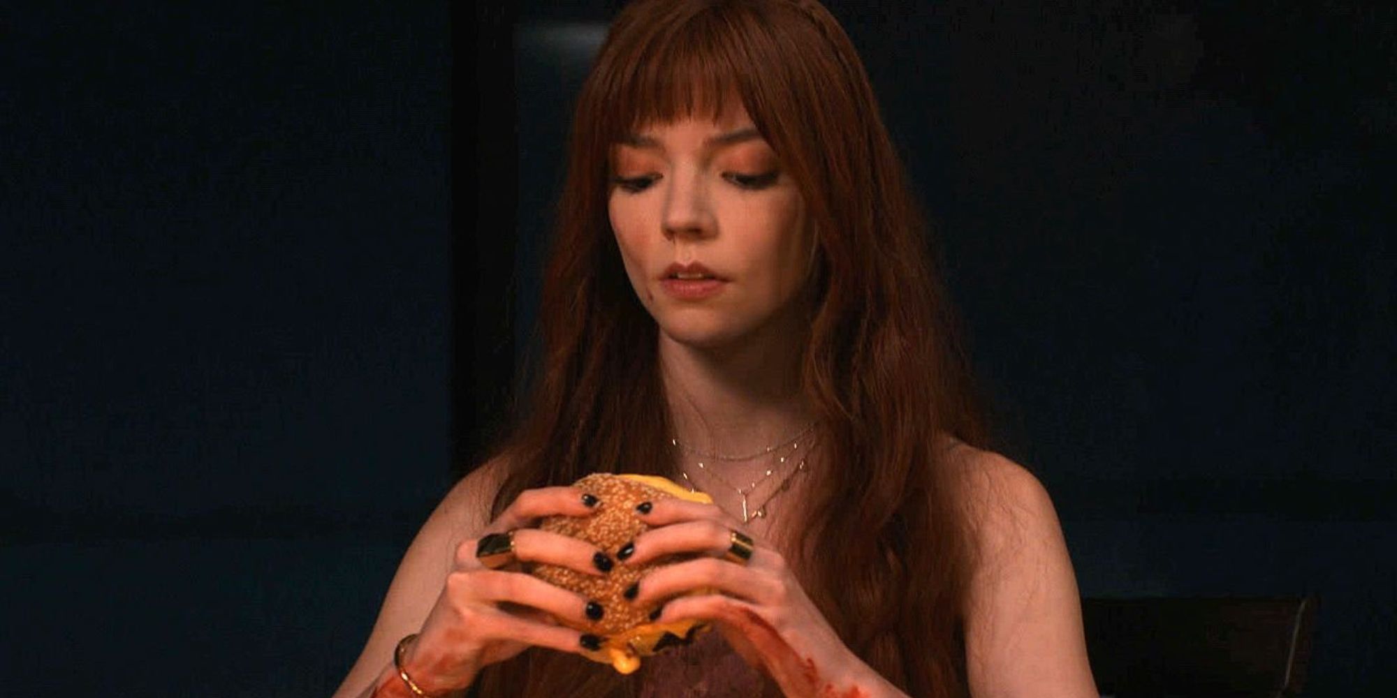 Anya Taylor-Joy eating a burger in The Menu