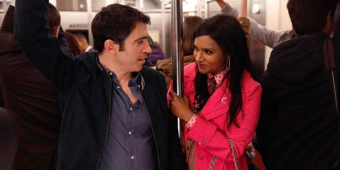Mindy Kaling as Mindy and Chris Messina as Danny standing close and smiling at each other on the subway in The Mindy Project