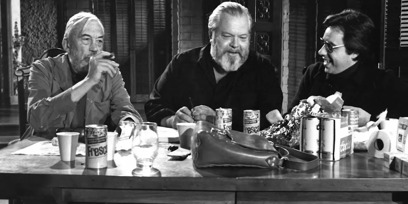 Orson Welles, Peter Bogdanovich, and John Huston laughing and talking together in The Other Side of the Wind