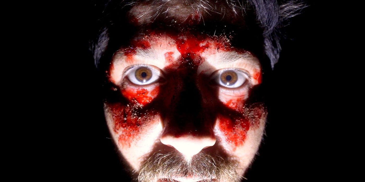 a close of Robbie Banfitch's face covered in blood in a scene from The Outwaters. 