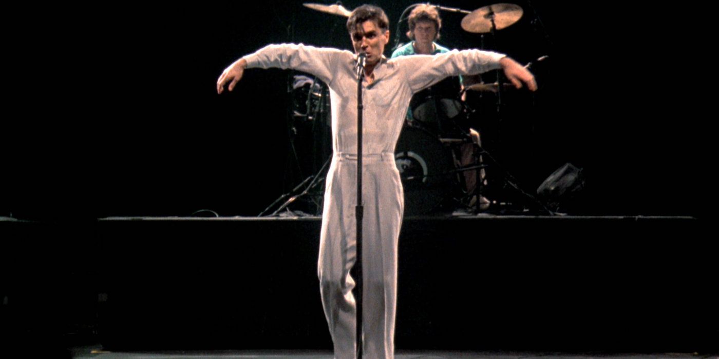 David Byrne sings and dances in front of a microphone in 'Stop Making Sense'