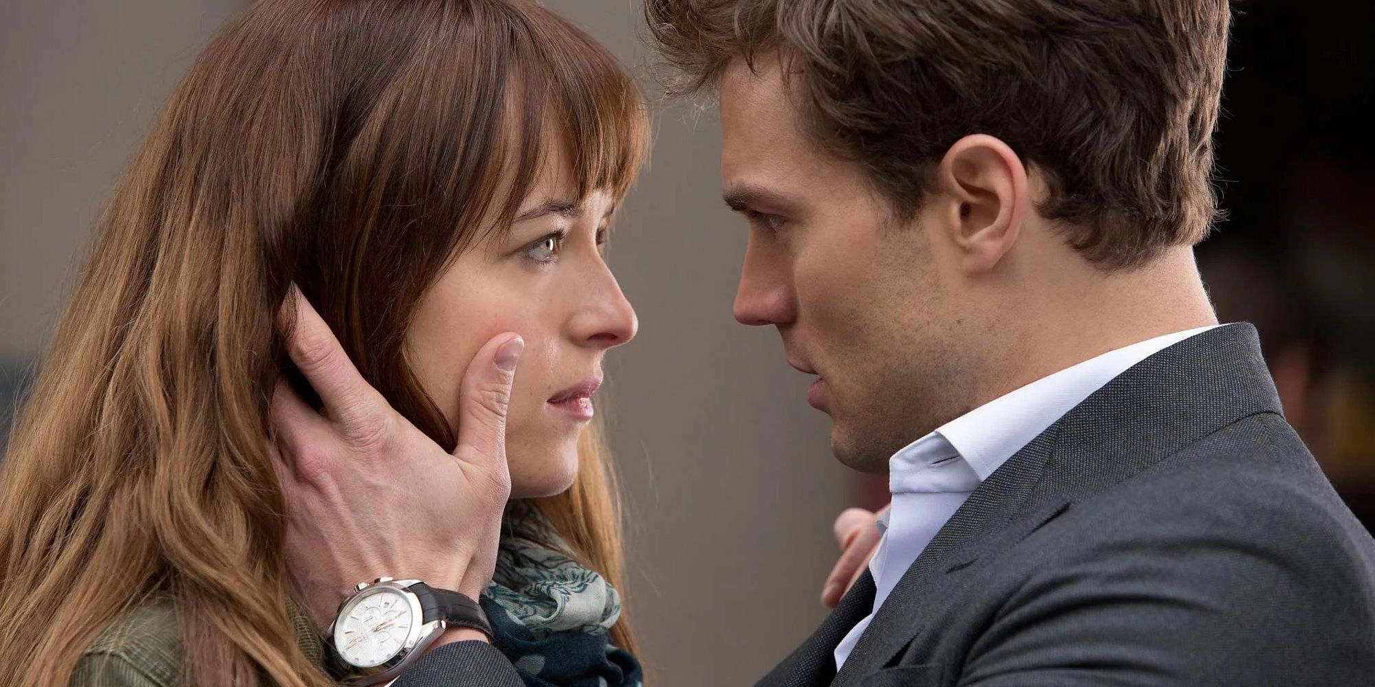 Jamie Dornan as Christian Grey holding Dakota Johnson as Anna's face in 50 Shades of Grey