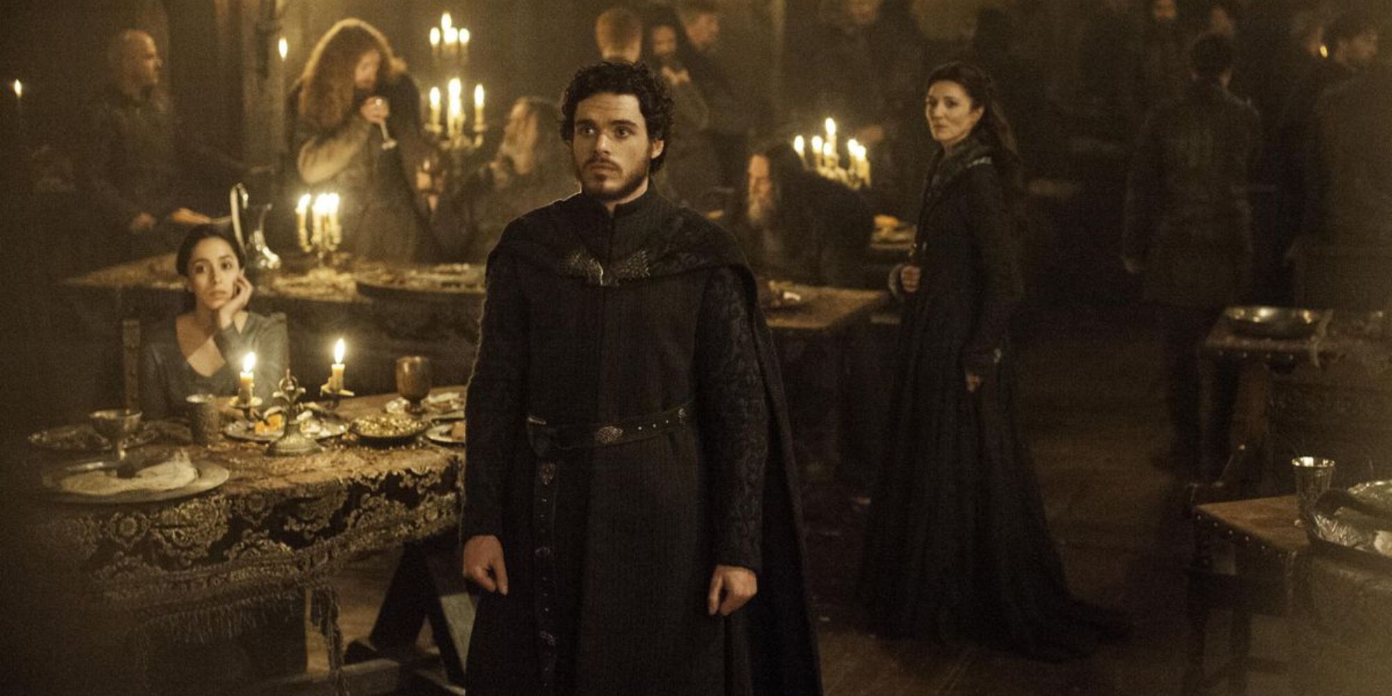 Robb Stark standing still and facing someone off-camera in Game of Thrones.