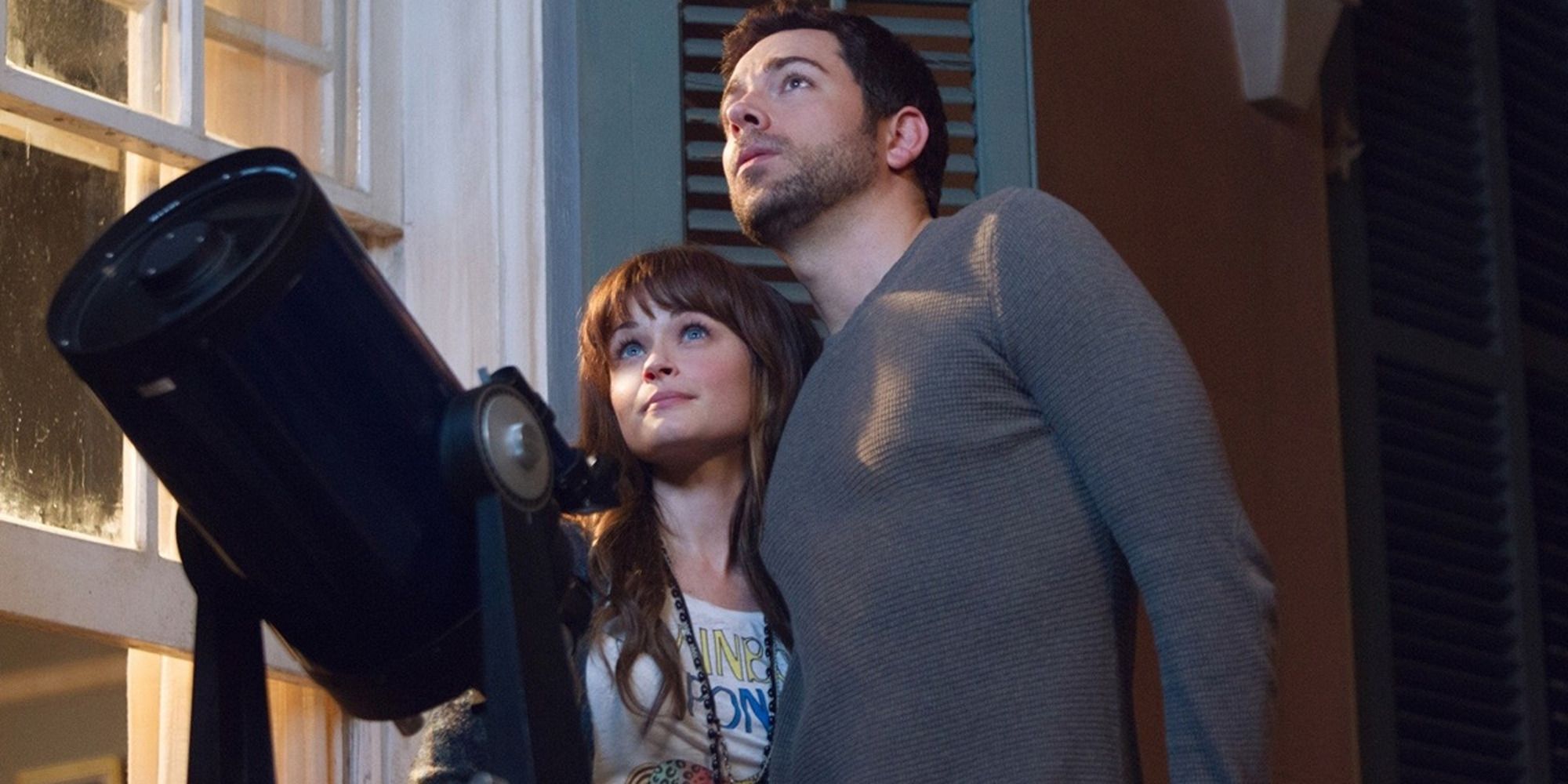 Alexis Bledel and Zachary Levi looking at the night sky in front of a telescope in 'Remember Sunday'