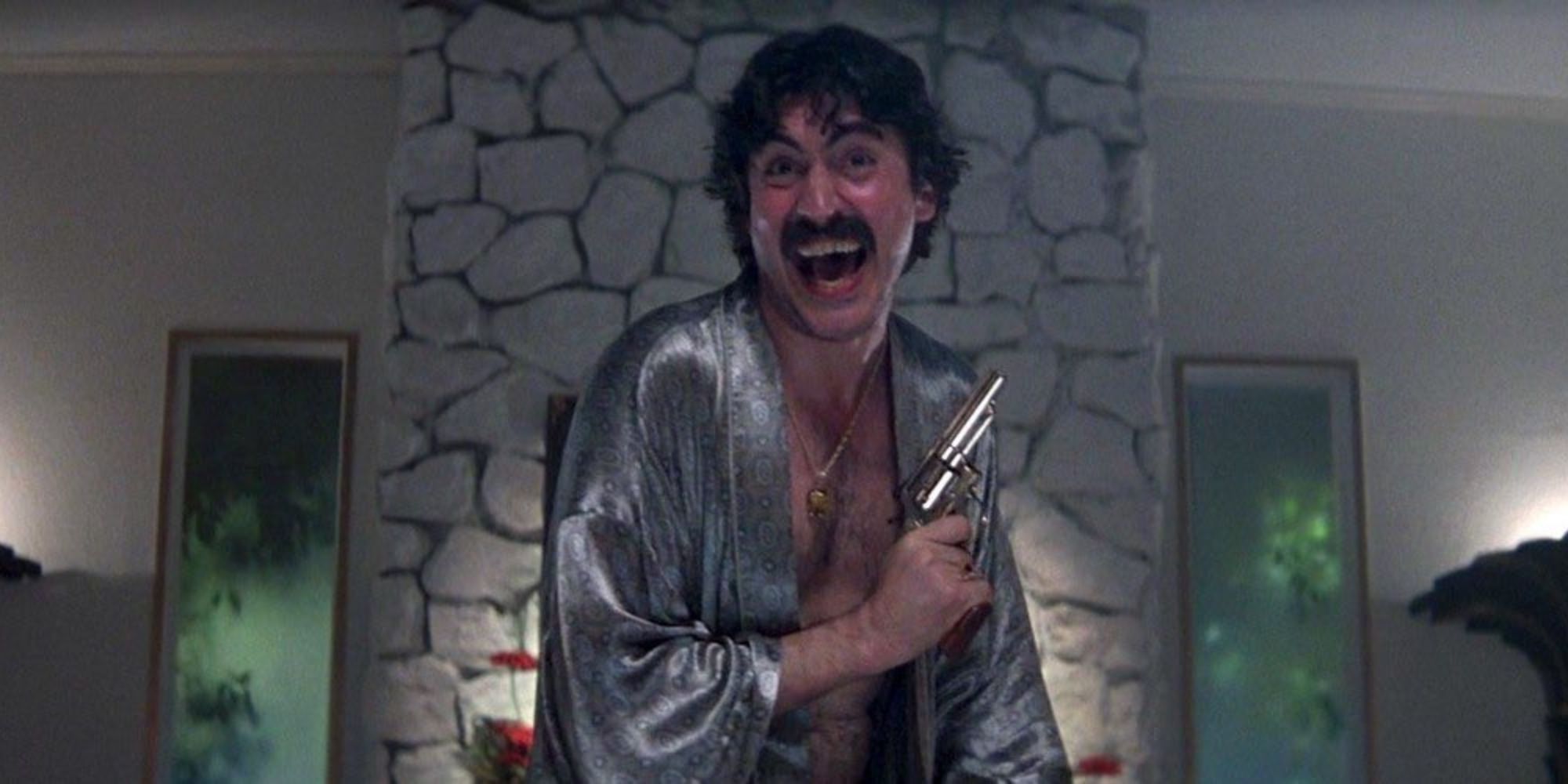Alfred Molina as Rahad Jackson in a silver robe holding a gun in Boogie Nights 