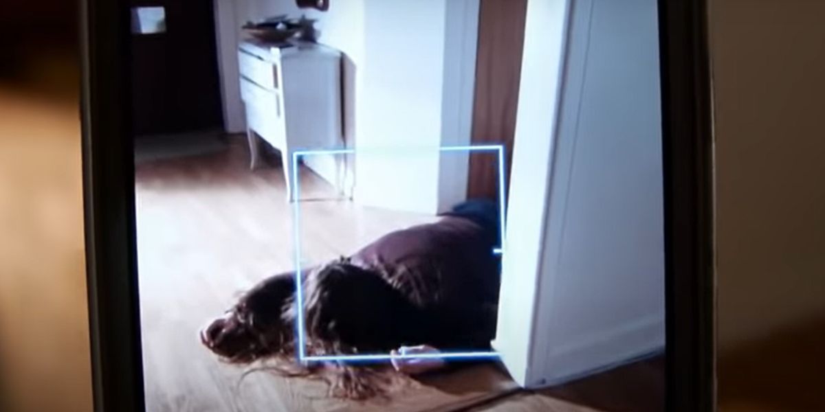 Le corps d'une femme sur le sol à travers l'appareil photo d'un téléphone.