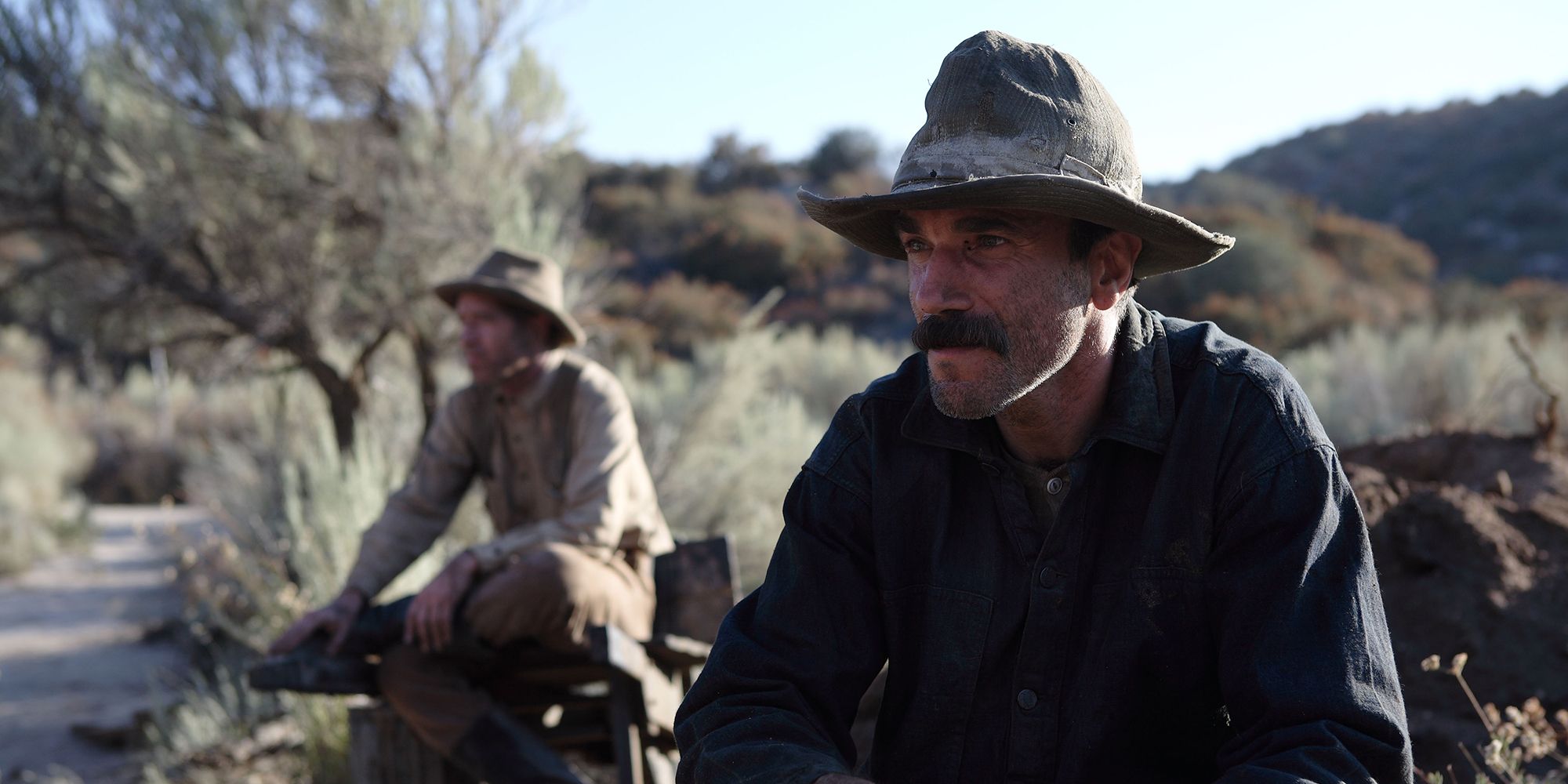 Daniel Day-Lewis sitting down in There Will Be Blood.