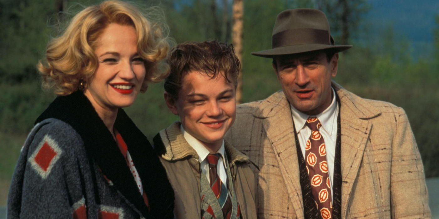 Ellen Barkin, Leonardo DiCaprio, and Robert De Niro standing together and smiling in This Boy's Life