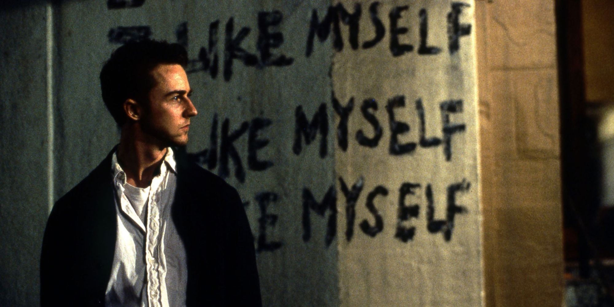 Edward Norton standing in front of a wall in a scene from 'Fight Club'